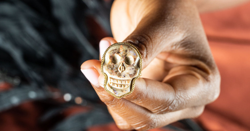 Andamooka Opal Skull Ring against a red background
