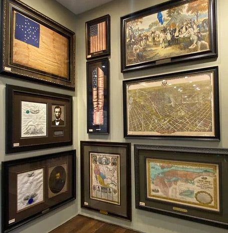 image with three framed items on the left wall and six framed items on the right wall in a gallery style 