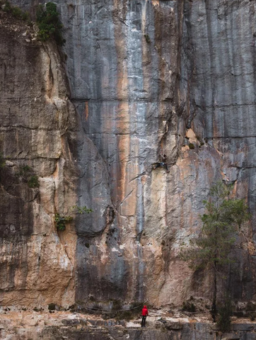 A Climber dwarfed by a huge, beautiful rock face