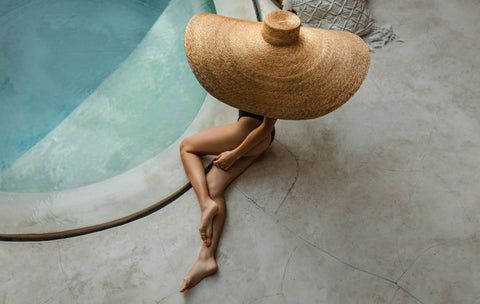 Girl laying by the pool wearing The Base Foundation on her legs in the shade Passionate from Baseofsweden