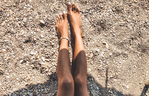 Legs in the sand wearing The Base Foundation