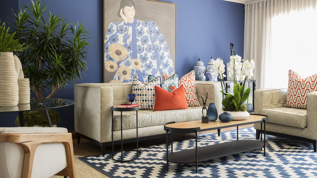 Contemporary interior design of open plan living room with bold pops of blue and orange 