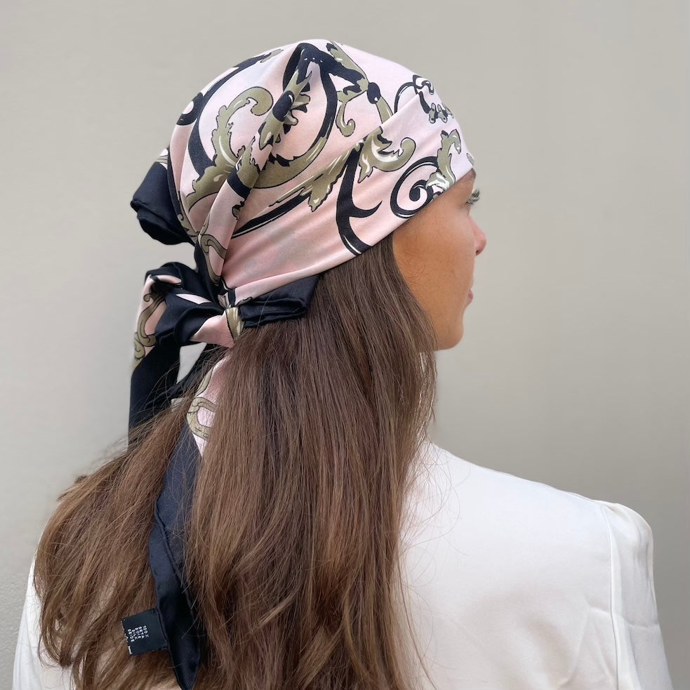 woman wearing pink and black scarf as a bandana facing away