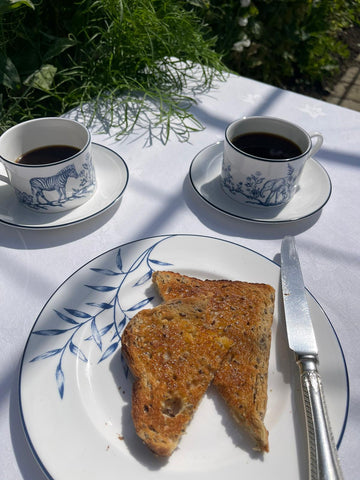 Nina Campbell Serengeti fine bone china plate with toast and coffee cups on a breakfast table in the sunshine.