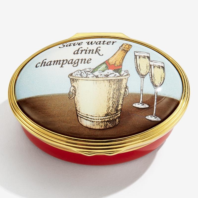 Image of Halcyon Days enamel pillbox with a message instructing 'Save Water, Drink Champagne'