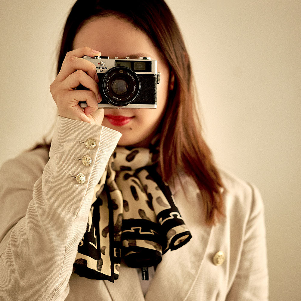 Image of woman taking picture on old film camera 