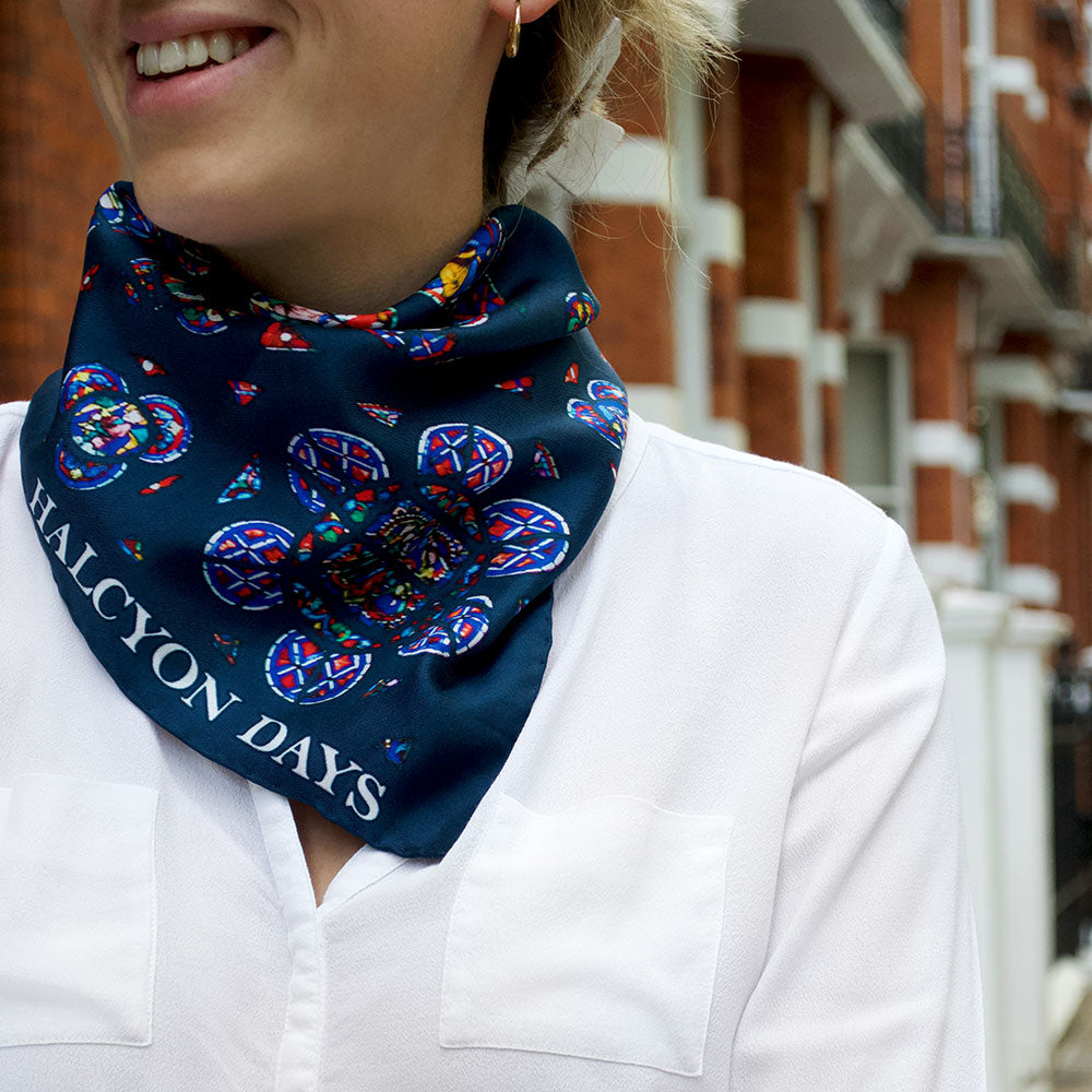 Image of woman wearing blue and colourful scarf smiling