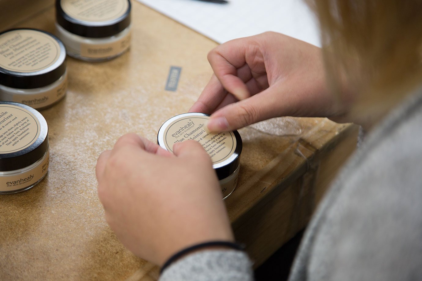 hand bottling facial moisturizer jar