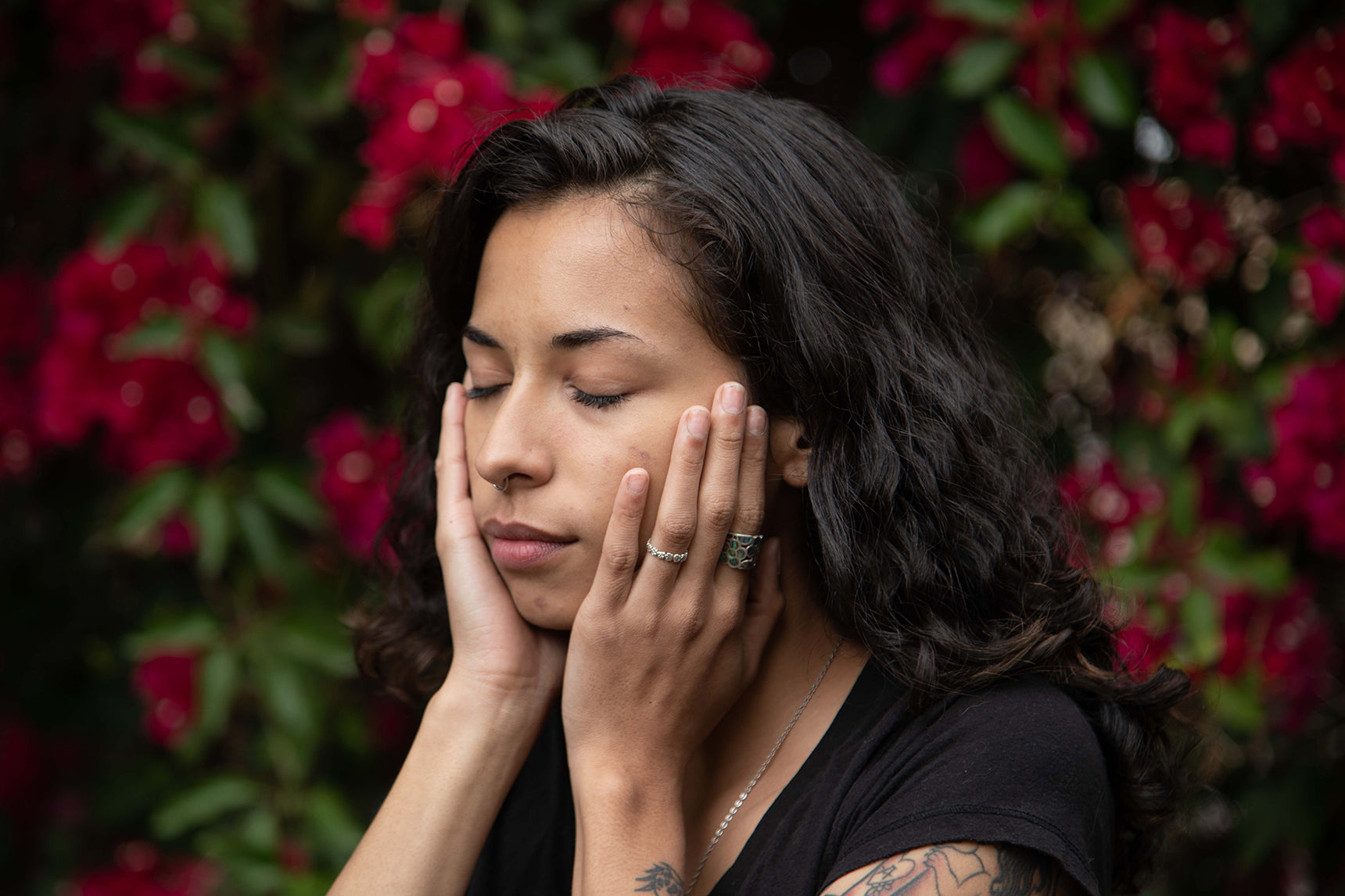 the hands on face in front of flowers