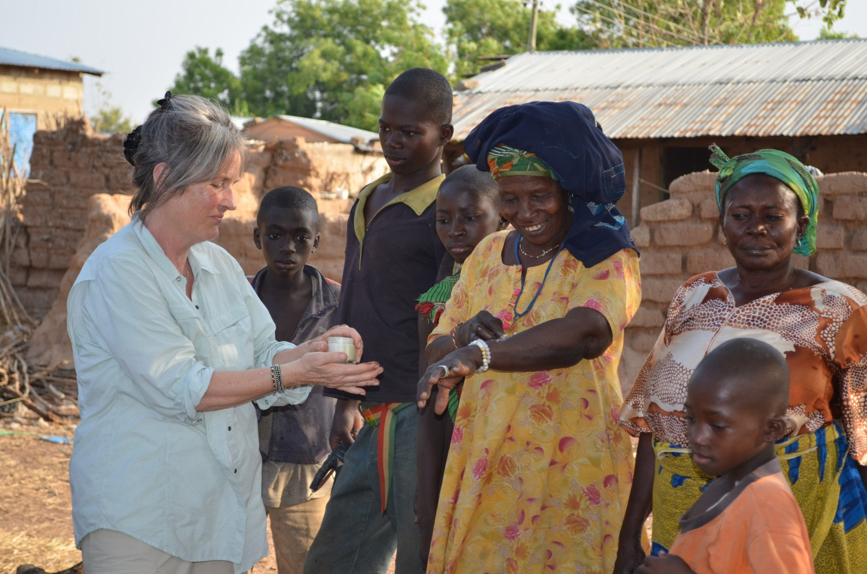 evan healy sharing whipped shea butter with kperisi village woman
