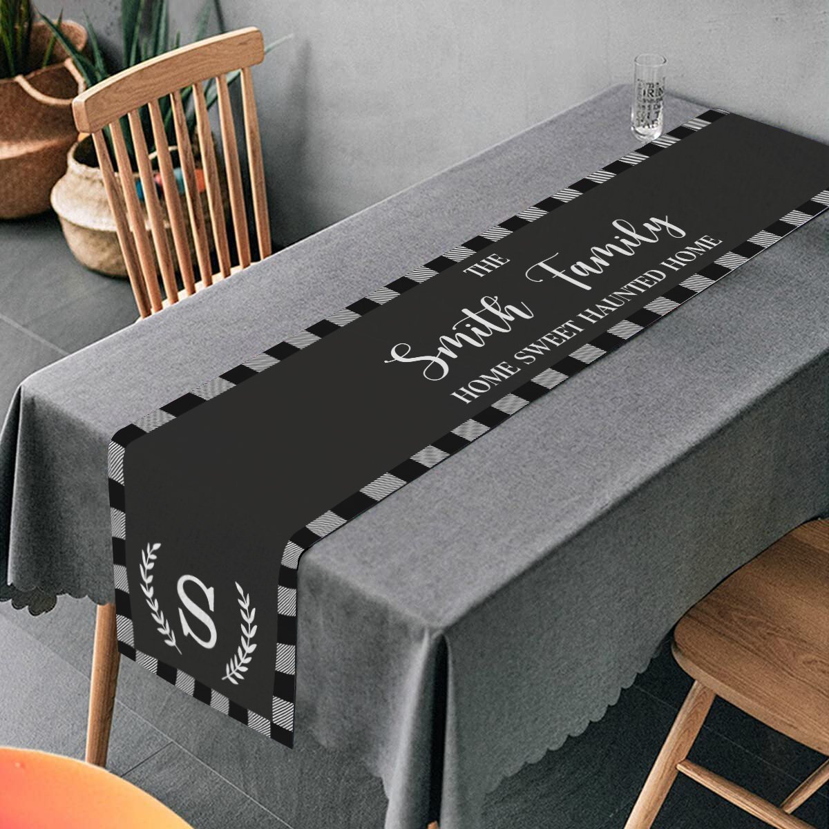 Table Runner print family name, initial, and the phrase "Home Sweet Haunted Home" in white color on a black color background