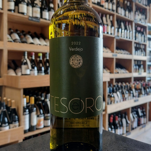 A bottle of white wine with a dark green label bearing the name Tesoro with a gold emblem