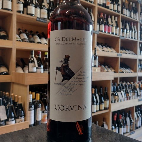 A bottle of pale red wine with a white label with an image of a bird with a hat and cane. It has the names Ca Dei Maghi and Corvina on the label also.