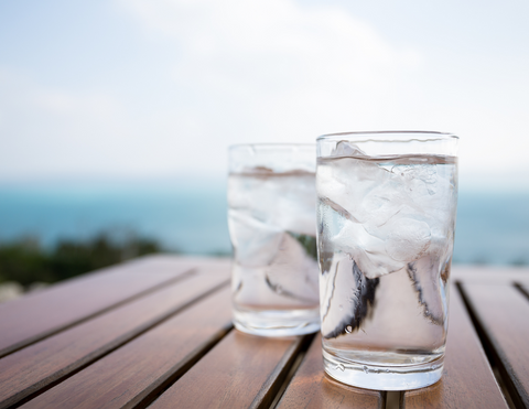 two glasses of water on a wood table