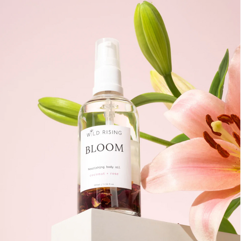 image of a bottle of oil by Wild Rising called Bloom in front of an orchid flower