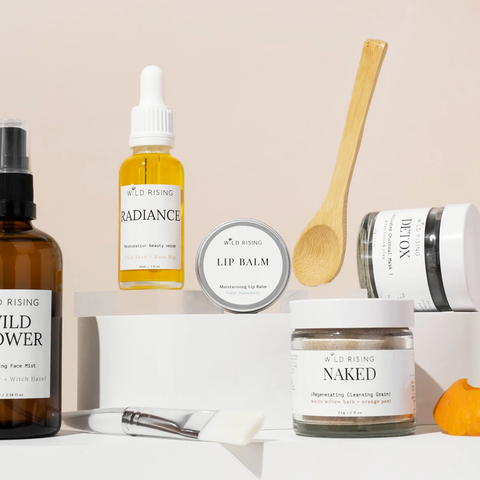 image of 5 skincare products by Wild Rising Skincare with some props