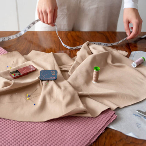 sustainable haberdashery on a table with a person holding a tape measure