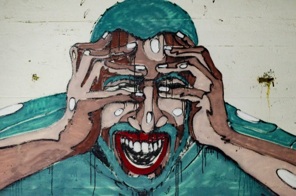 eco anxiety streetart: ängstliche Person verdeckt seine Augen mit den Händen