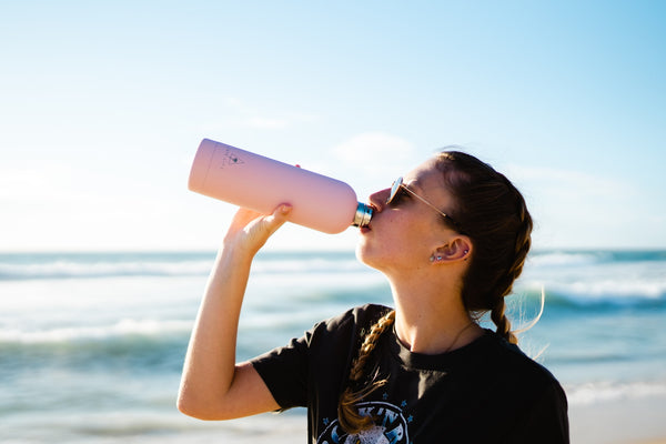 Person drinks water from a sustainable water bottle