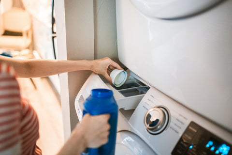 Person fills washing machine with care products