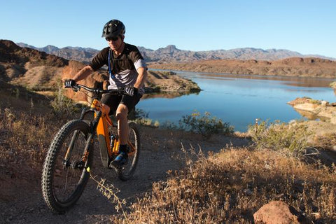 MOUNTAIN BIKER WITH SCENIC VIEW OF LAKE IN BACKGROUND