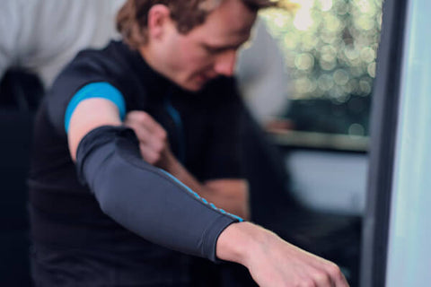 CYCLIST PUTTING ON ARM WARMERS