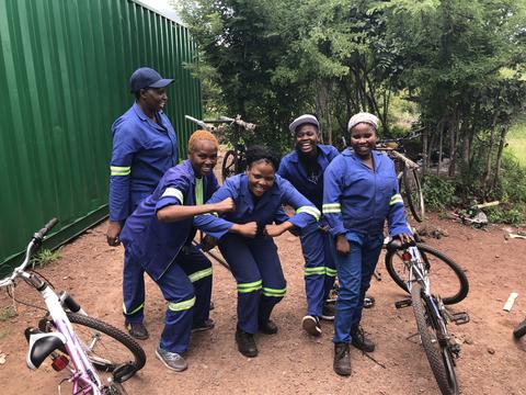 LOCAL TANZANIA FEMALE BIKE MECHANICS GOOFING AROUND FOR THE CAMERA