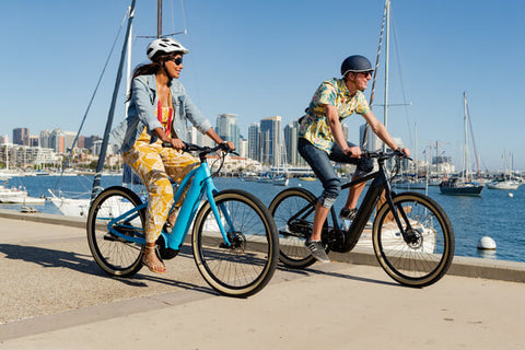 Cyclists riding e-bikes by the bay.