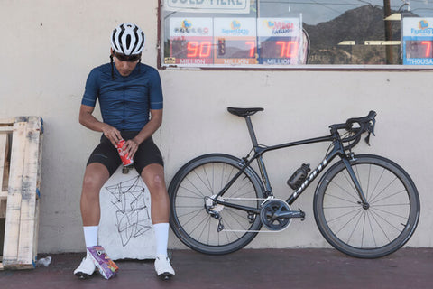 Road cyclist taking a break with snacks.