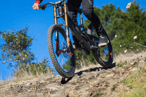 MOUNTAIN BIKER THROWING ROCKS FROM REAR TIRE