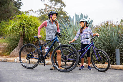 MOTHER AND DAUGHTER BIKING AND SMILING