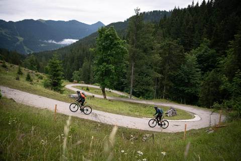 CYCLISTS ON E-BIKES CLIMBING FOREST FIRE ROADS