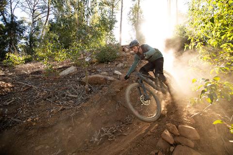 MOUNTAIN BIKER ON THE MEGATOWER PINNING A TURN OFF ROAD