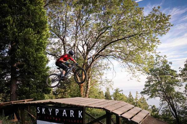 MOUNTAIN BIKER AIRS OVER A WOOD JUMP AT SKYPARK