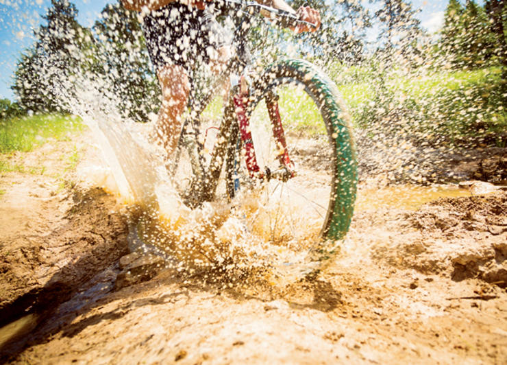 A mountain bike splashing through a puddle