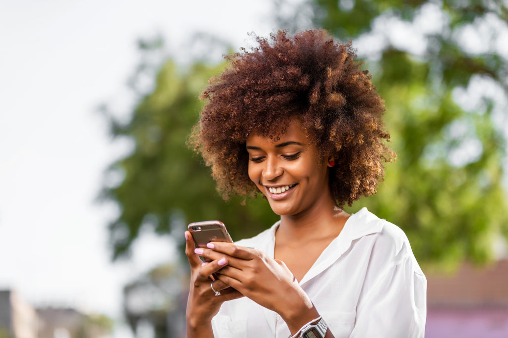 Beautiful lady texting on her phone smile face