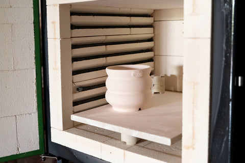 Electric pottery kiln with a bisqued pot inside