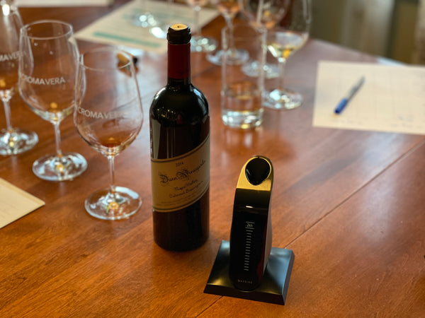 An image of wine glasses, worksheets, and a bottle of wine next to the Aveine Smart Aerator