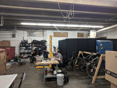 Ben sitting in the manufacturing area working on his computer