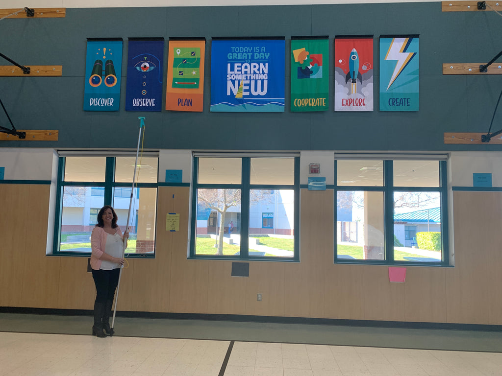 A principal stands in front of a set of banners.