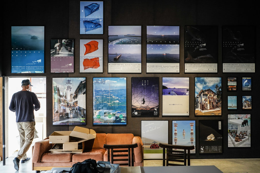 A wall of posters promoting tourism to Naoshima, including several from the Setouchi Triennale. At the time of the interview, the space was being transformed back into a gallery from a temporary theater where Shitamichi showed films set in the region.