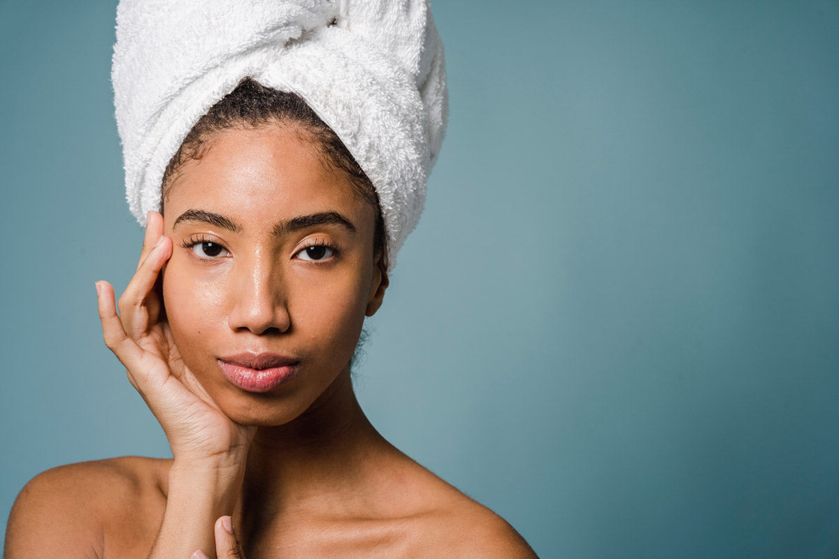 A woman with clean skin and her hair wrapped in a towel