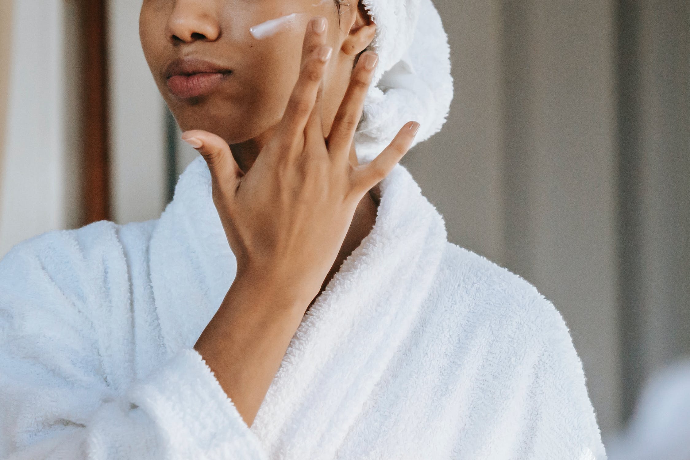 A woman applies a cream.