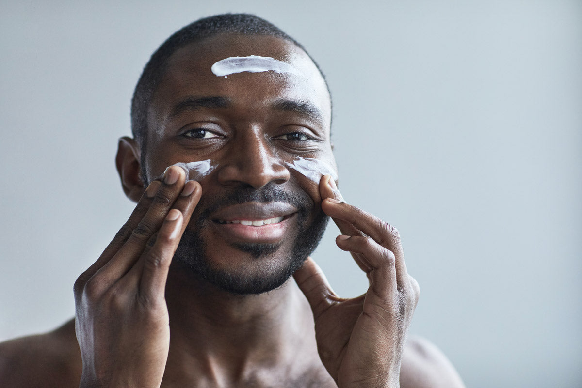 A man applying moisturizer to his face