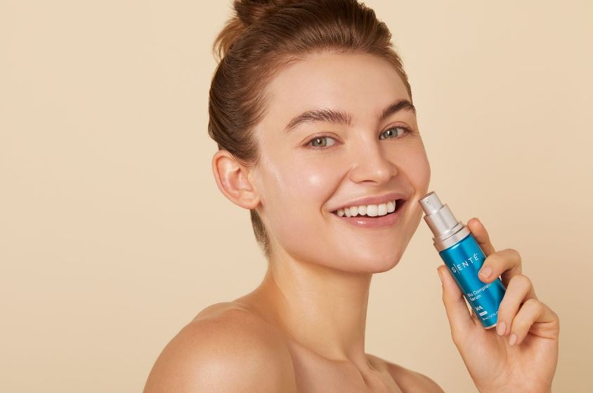 A woman holding Senté Bio Complete Serum—an excellent winter skincare product