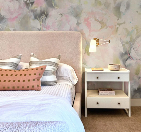 Peony wallpaper mural on a bedroom wall behind a headboard