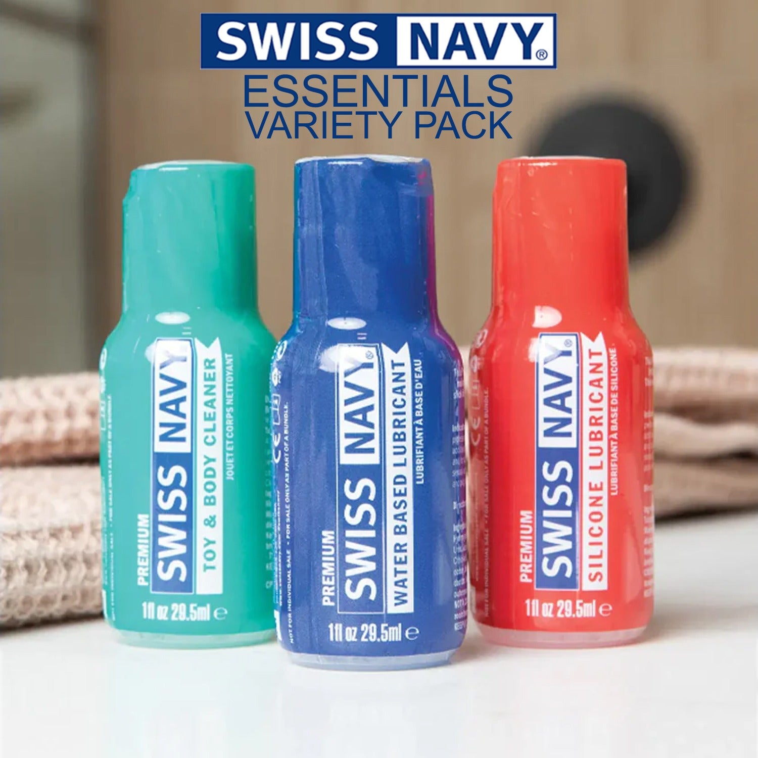 Premium Swiss Navy Toy & Body Cleaner, Premium Swiss Navy Water Based Lubricant, and Premium Swiss Navy Silicone Lubricant 1 fl oz / 29.5 ml bottles standing beside each other. On the top is the Swiss Navy logo, the product name: Essentials Variety Pack.