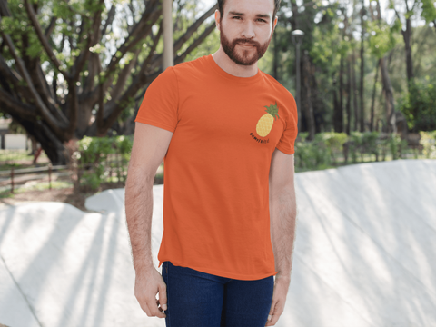 modele-homme-barbu-roux-sourire-tshirt-orange-ananas-ohmyfruits-exterieur-arbre-feuilles-beton
