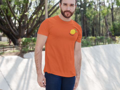 modele-homme-barbu-roux-sourire-tshirt-orange-citron-ohmyfruits-exterieur-arbre-feuilles-beton