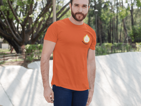 modele-homme-barbu-roux-sourire-tshirt-orange-poire-ohmyfruits-exterieur-arbre-feuilles-beton